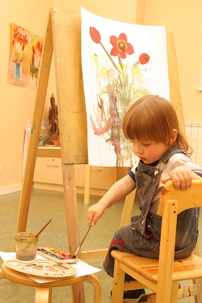 Маленькая девочка рисует красками - фото