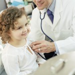 Доктор прослушивает сердечко маленькой девочке - фото