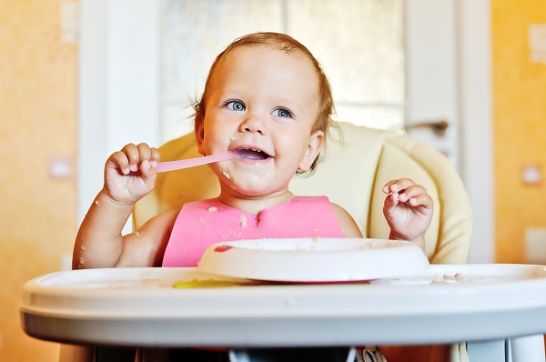 Маленький ребенок ест кашу - фото