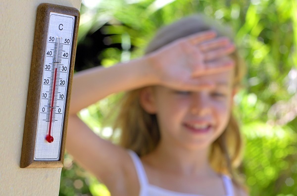 Девочка летним днем возле термометра - фото