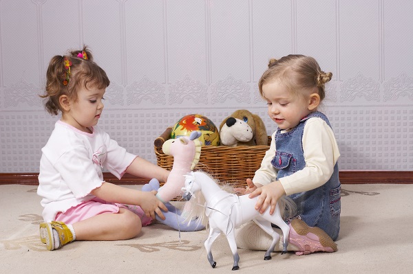 Маленькие девочки играют с игрушками - фото