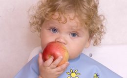 Малыш ест яблоко - фото