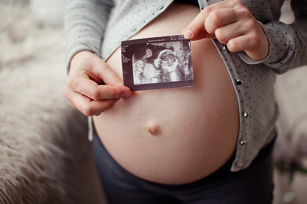 Животик беременной и фото УЗИ будущего малыша - фото