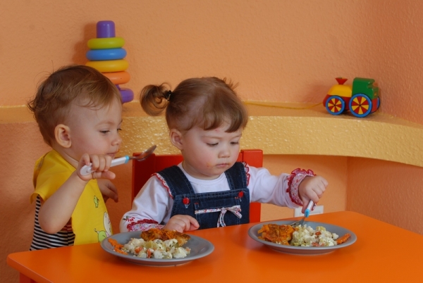 Діти їдять за столом.