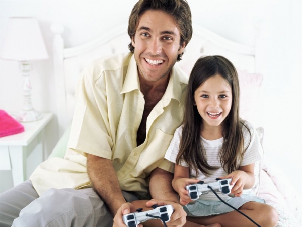 Отец и дочь играют в видеоигру - фото