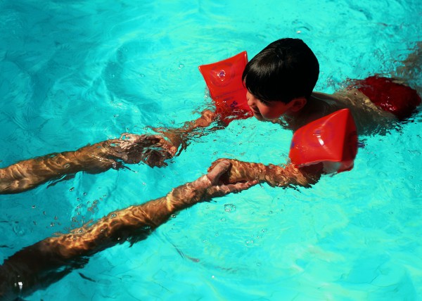 Ребенок в бассейне учится плавать - фото