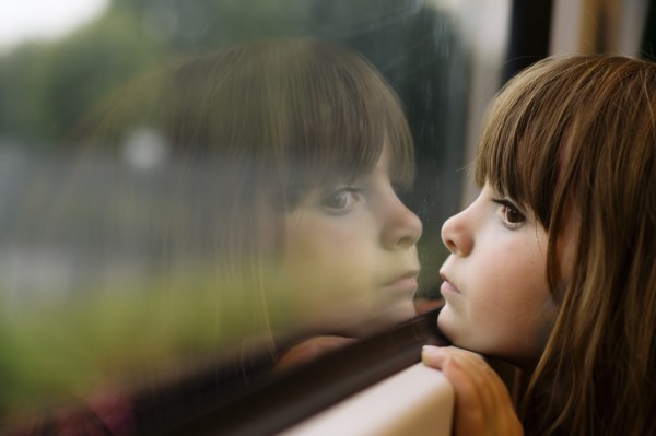 Девочка в автомобиле смотрит в окно - фото