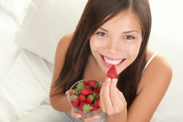 Женщина ест клубнику - фото