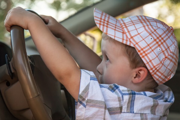 Маленький мальчик за рулем автомобиля - фото