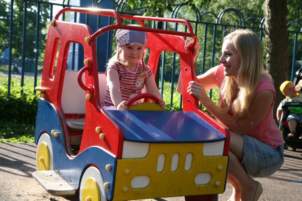 Девочка с мамой играют на детской площадке - фото