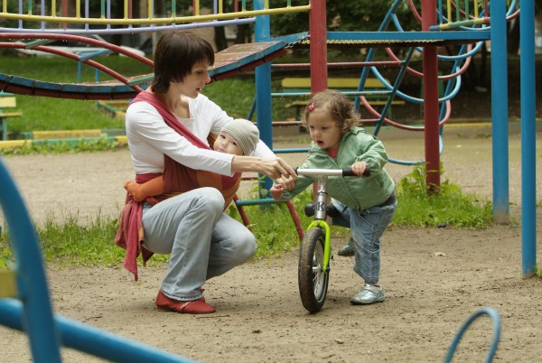 Мама с малышом на детской площадке - фото