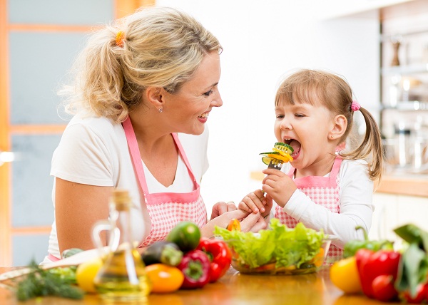 Мама с девочкой готовят из овощей - фото