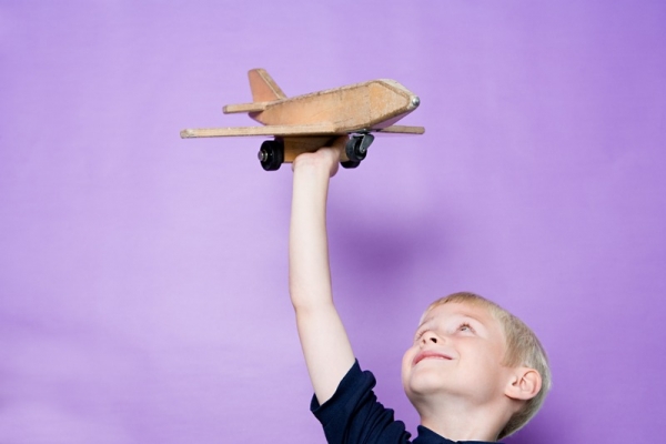 Мальчик держит самолет - фото