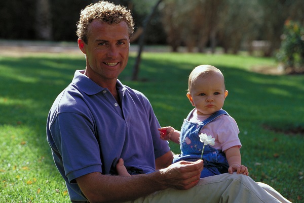 Молодой папа с ребенком на руках - фото
