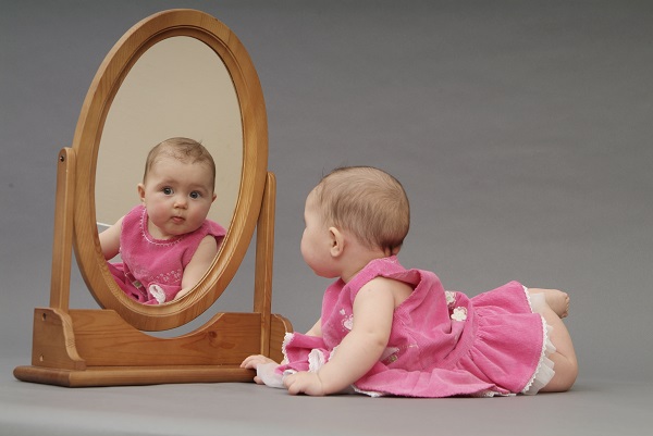 Маленький ребенок у зеркала - фото