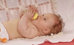 Ребенок пьет из бутылочки - фото
