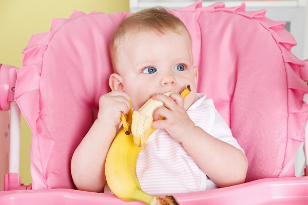Ребенок ест банан - фото