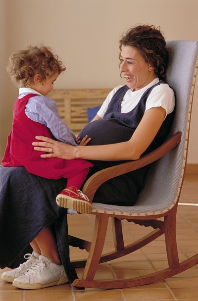 Беременная с маленьким ребенком наруках - фото