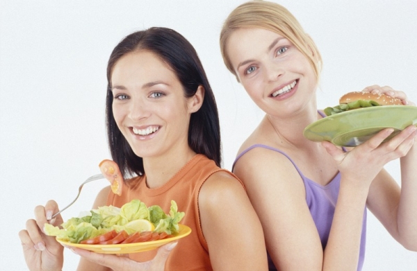 Женщины едят салат