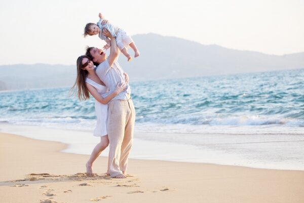 мама и папа с ребенком веселятся, пляж, море - фото
