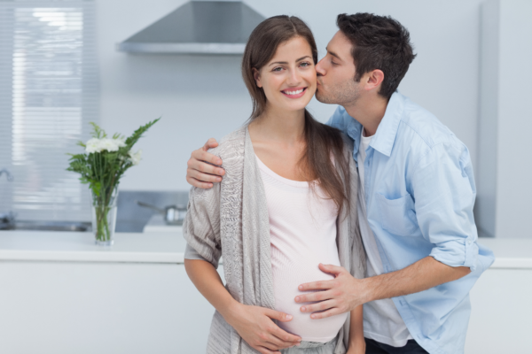 беременную обнимает муж
